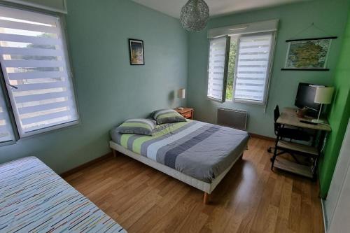 une chambre avec un lit, un bureau et des fenêtres dans l'établissement Villa bleue, à Le Palais-sur-Vienne