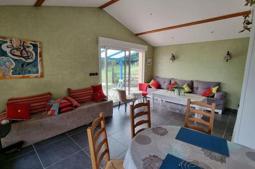 un salon avec un canapé, une table et des chaises dans l'établissement Villa bleue, à Le Palais-sur-Vienne