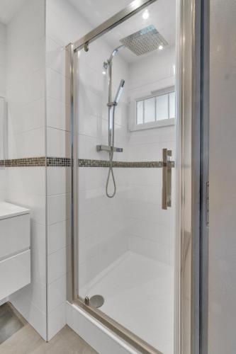 une douche avec une porte en verre dans une salle de bain dans l'établissement Le Bleu SAPHIR, à Tresserves