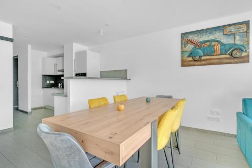 une salle à manger avec une table en bois et des chaises jaunes dans l'établissement Le Bleu SAPHIR, à Tresserves