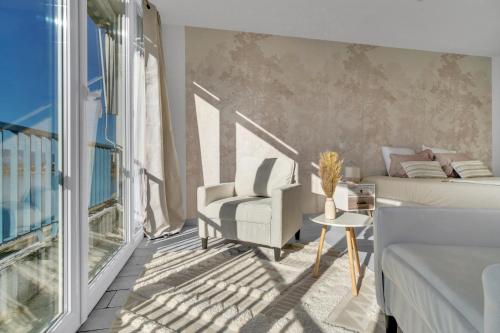 une chambre avec un lit, une chaise et une fenêtre dans l'établissement Le Bleu SAPHIR, à Tresserves