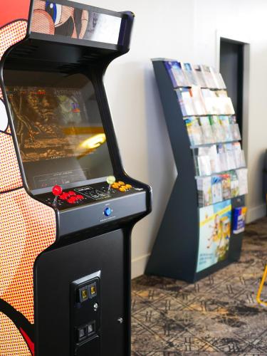 a video game machine sitting next to a couch at ibis Styles Poitiers Nord in Poitiers