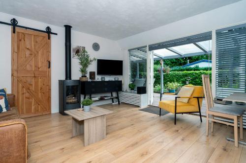 a living room with a wooden floor and a sliding door at Landhuisje 31 'De Akkersteen' Bospark IJsselheide Zwolle Hattemerbroek in Hattemerbroek