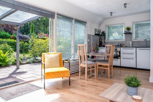 a kitchen and dining room with a table and chairs at Landhuisje 31 'De Akkersteen' Bospark IJsselheide Zwolle Hattemerbroek in Hattemerbroek