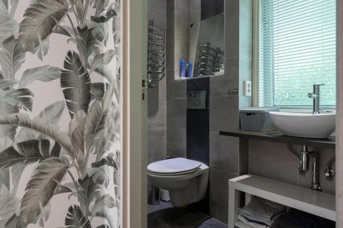a bathroom with a toilet and a sink at Landhuisje 31 'De Akkersteen' Bospark IJsselheide Zwolle Hattemerbroek in Hattemerbroek