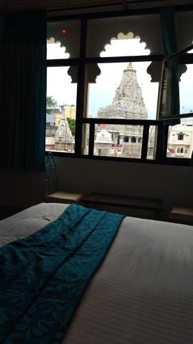 a bedroom with a view of a building through a window at Baba Palace - A Heritage Hotel, Udaipur in Udaipur
