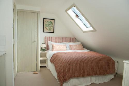 a bedroom with a bed and a skylight at Luxurious 3 Bedroom Cottage in New Alresford