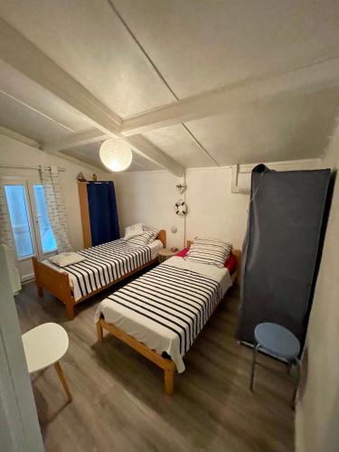 une chambre avec deux lits et une chaise dedans dans l'établissement Paisible maison familiale Animaux acceptés, à Gujan-Mestras