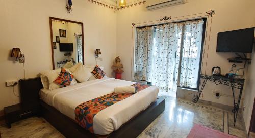 a bedroom with a large bed and a large window at Baba Palace - A Heritage Hotel, Udaipur in Udaipur