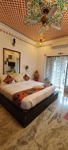 a bedroom with a large bed with a ceiling at Baba Palace - A Heritage Hotel, Udaipur in Udaipur