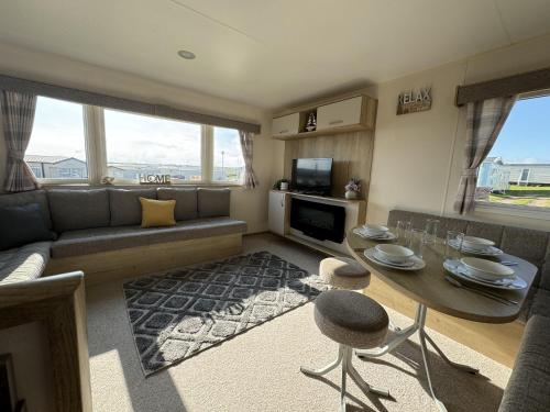 a living room with a table and a couch at Perranporth Coastal Retreat- Sleeps8 in Perranporth