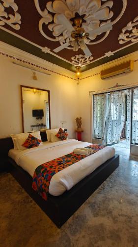 a bedroom with a large bed with a large ceiling at Baba Palace - A Heritage Hotel, Udaipur in Udaipur