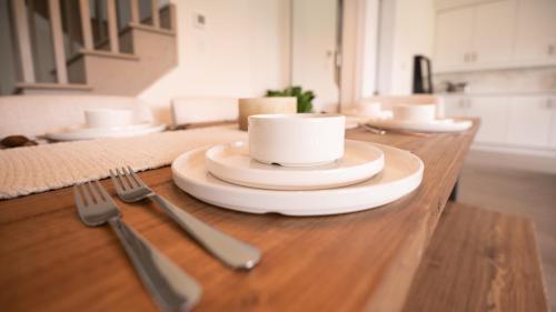 a table with plates and utensils on top at Spotless 5 bed and 4 bath with Wi-Fi and 1hr to Niagara in Hamilton