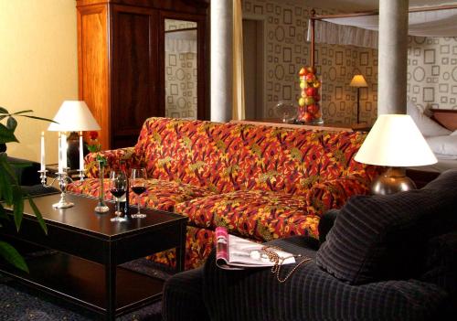 a living room with a couch and a table at Hotel BEI SCHUMANN in Kirschau