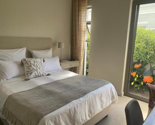 a bedroom with a bed and a window with a balcony at 23 Grace in Cape Town