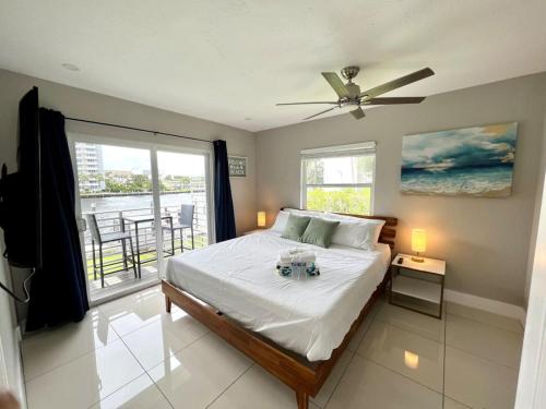a bedroom with a bed with a ceiling fan and a balcony at Renovated Intercoastal 2Bdrm 1 bath condo Walk to Beach in Fort Lauderdale