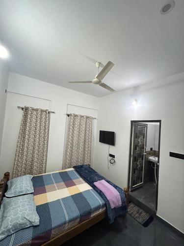a bedroom with a bed and a ceiling fan at Travel INN Mysore in Vānivilāsa Puram