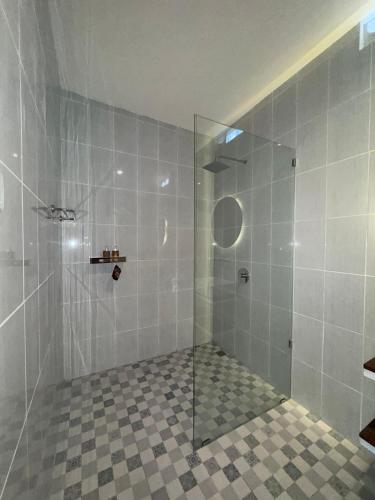 a bathroom with a shower with a glass door at Omah Santai Canggu in Canggu