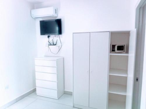 a white room with a white cabinet and a tv at Tropical Paradise Villa in Sosua in Sosúa