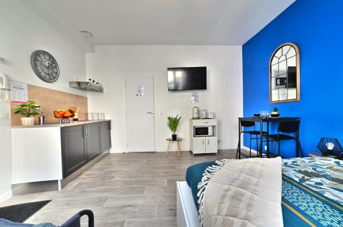 Cette chambre bleue et blanche dispose d'un lit et d'une cuisine. dans l'établissement Paradis Bleu - Coeur de ville, Tv 4K, Netflix, Fibre, Confortable, Calme, à Saintes