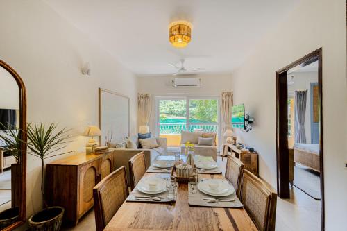 a dining room and living room with a table and chairs at Alaya Stays 1 BHK with Balcony & Pool - Veera Marina in Goa