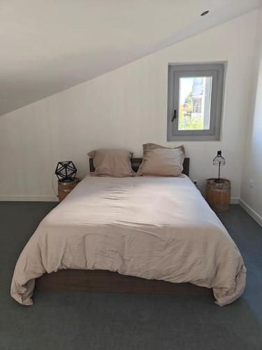 une chambre avec un grand lit blanc avec une fenêtre dans l'établissement Duplex 4 personnes, à Saint-Gaudens