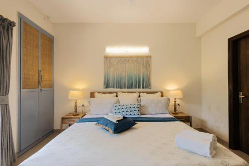 a bedroom with a large white bed with two pillows at Alaya Stays 1 BHK with Balcony & Pool - Veera Marina in Goa