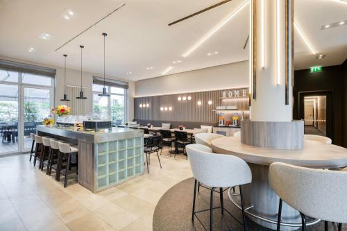 un restaurant avec un bar, des tables et des chaises dans l'établissement Citadines Kurfürstendamm Berlin, à Berlin