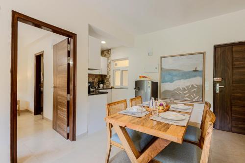 a dining room with a wooden table and chairs at Alaya Stays 1 BHK with Balcony & Pool - Veera Marina in Goa