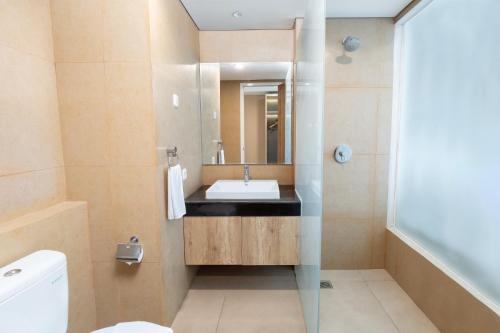 ein Badezimmer mit Waschbecken und Spiegel in der Unterkunft Kamala Bali Resort in Nusa Dua