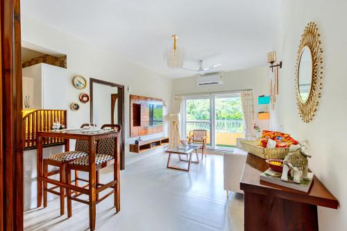 a kitchen and living room with a table and chairs at Alaya Stays 1 BHK with Balcony & Pool - Veera Marina in Goa