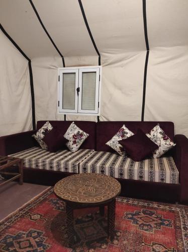 a living room with a couch in a tent at Oasis Luxury Camp in Merzouga