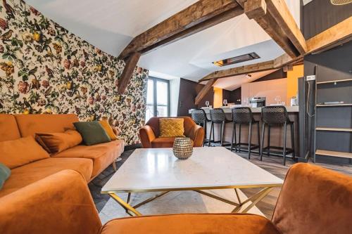 - un salon doté d'un mobilier orange et d'une table dans l'établissement Au Coin de Saint-Jacques Reims hypercentre, à Reims