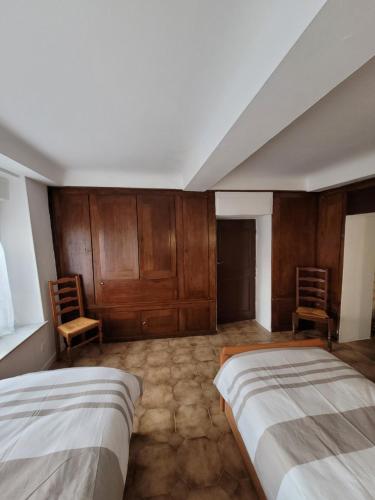 a bedroom with two beds and wooden cabinets at Josie's Cozy Home in Boulay - Moselle