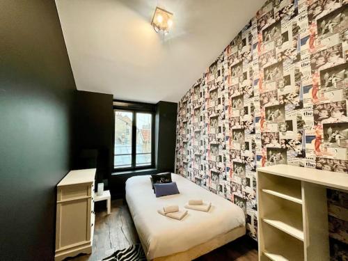 - une chambre avec un lit et un mur recouvert de photographies dans l'établissement Au Coin de Saint-Jacques Reims hypercentre, à Reims