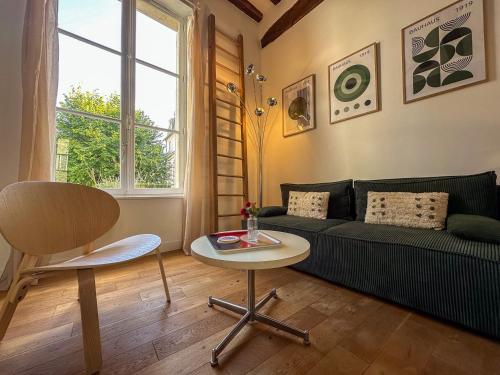 a living room with a couch and a table at Le jardinet de la cathédrale in Chartres