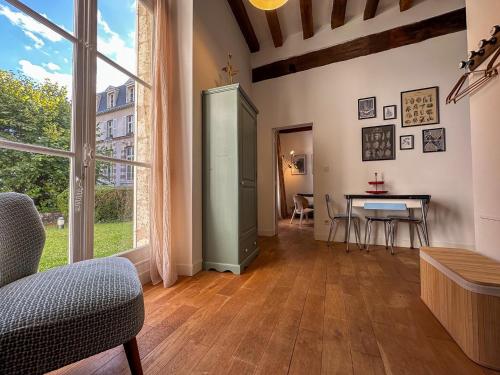 a living room with a table and a large window at Le jardinet de la cathédrale in Chartres