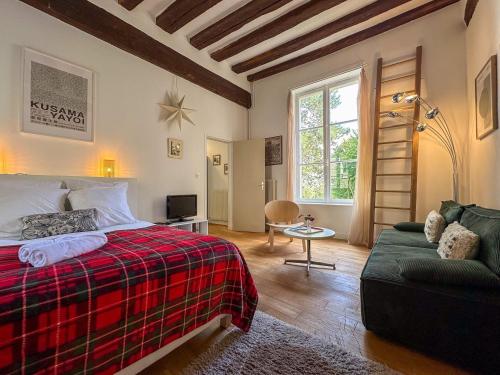 une chambre avec un lit et un canapé dans l'établissement Le jardinet de la cathédrale, à Chartres