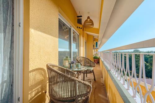 un balcón con mesa y sillas. en Alaya Stays 2 BHK with Balcony & Lift - Veera Marina, en Goa
