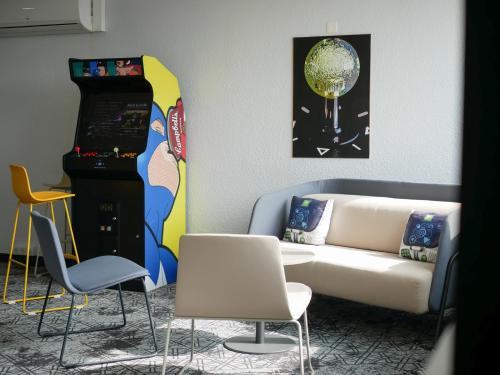a living room with a couch and a table and chairs at ibis Styles Poitiers Nord in Poitiers
