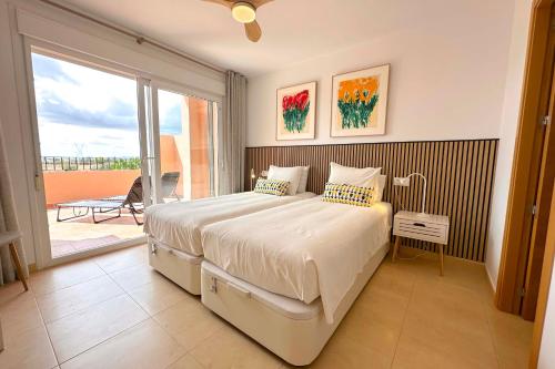 a bedroom with a large bed and a balcony at Vista Bonita - Mar Menor Golf Resort in Torre-Pacheco