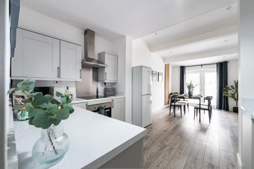 a kitchen with white cabinets and a table with chairs at Fairview House in Cleethorpes