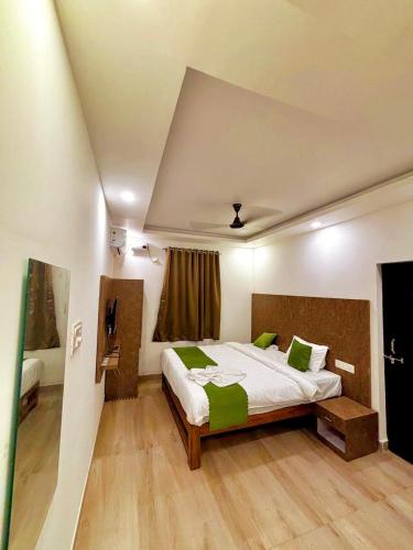a bedroom with a large bed with green pillows at Baga Beach Way in Baga
