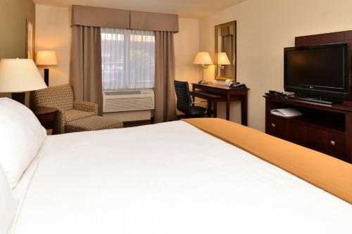 a hotel room with a large bed and a television at Holiday Inn Express Portland South - Lake Oswego by IHG in Lake Oswego