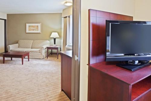a living room with a flat screen tv in a hotel room at Holiday Inn Express Portland South - Lake Oswego by IHG in Lake Oswego