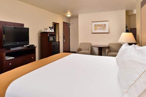 a hotel room with a bed and a flat screen tv at Holiday Inn Express Portland South - Lake Oswego by IHG in Lake Oswego