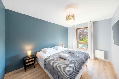 une chambre bleue avec un lit et une fenêtre dans l'établissement Lartdeco, à Thonon-les-Bains