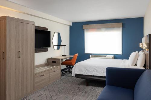 a bedroom with a bed and a desk with a television at Holiday Inn Express Portland South - Lake Oswego by IHG in Lake Oswego