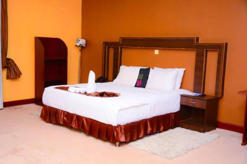 a bedroom with a large bed with a wooden headboard at The Country Inn Hotel in Kigali
