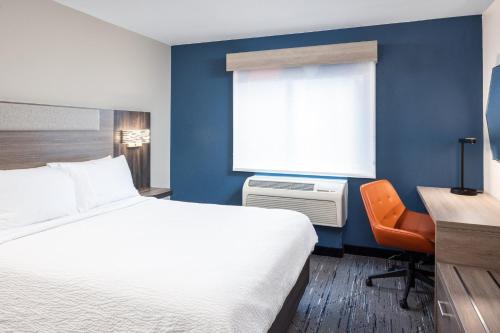 a hotel room with a bed and a desk and a window at Holiday Inn Express Portland South - Lake Oswego by IHG in Lake Oswego